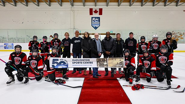 Mayor Adrian Foster, Regional Councillor Willie Woo, Councillor Margaret Zwart, Regional Councillor Granville Anderson and Councillor Sami Elhajjeh join members of the Clarington Flames U13 Girls Black hockey team on the ice at Darlington Sports Centre.