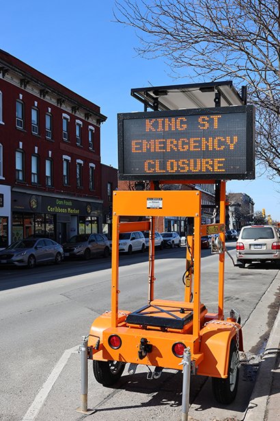 Temporary digital construction sign warns drivers of the road closure on King Street West.