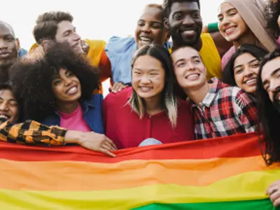 Crowd of multiracial people having fun together with pride flag.