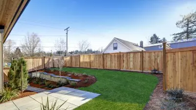 Backyard surrounded by wooden fence.