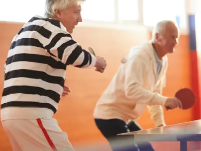 Older adults playing table tennis.