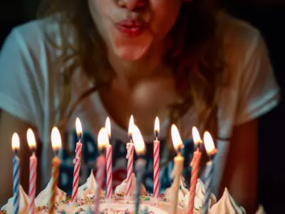 Picture of someone blowing out the candles of a birthday cake.