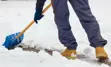 Close up photo of a person shoveling snow. 