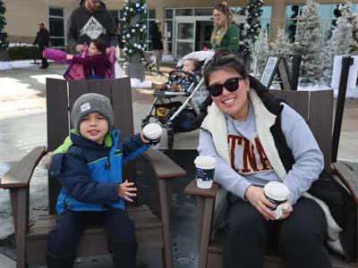 Mom and child warming up by the heater at the Courtice Outdoor skating rink.