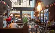 A busy restaurant filled with many diners and tables.