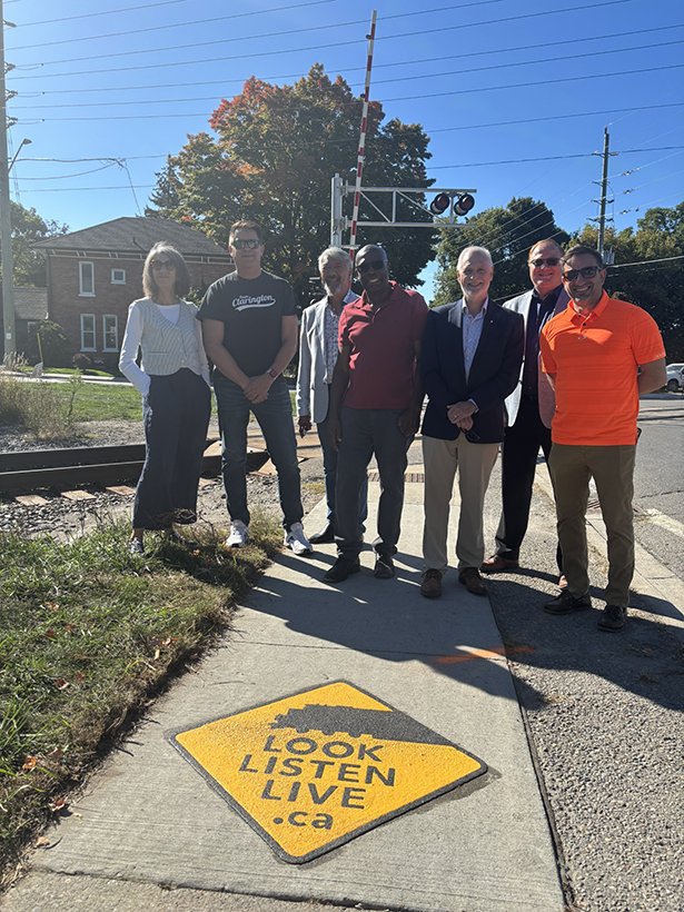 From left to right: Ward 4 Councillor Margaret Zwart, Ward 2 Councillor Lloyd Rang, Regional Councillor of Wards 3 and 4, Willie Woo, Regional Councillor of Wards 1 and 2, Granville Anderson, Mayor Adrian Foster, Deputy CAO of Planning and Infrastructure, Darryl Lyons, Ward 1 Councillor, Sami Elhajjeh. in front of the rail crossing.