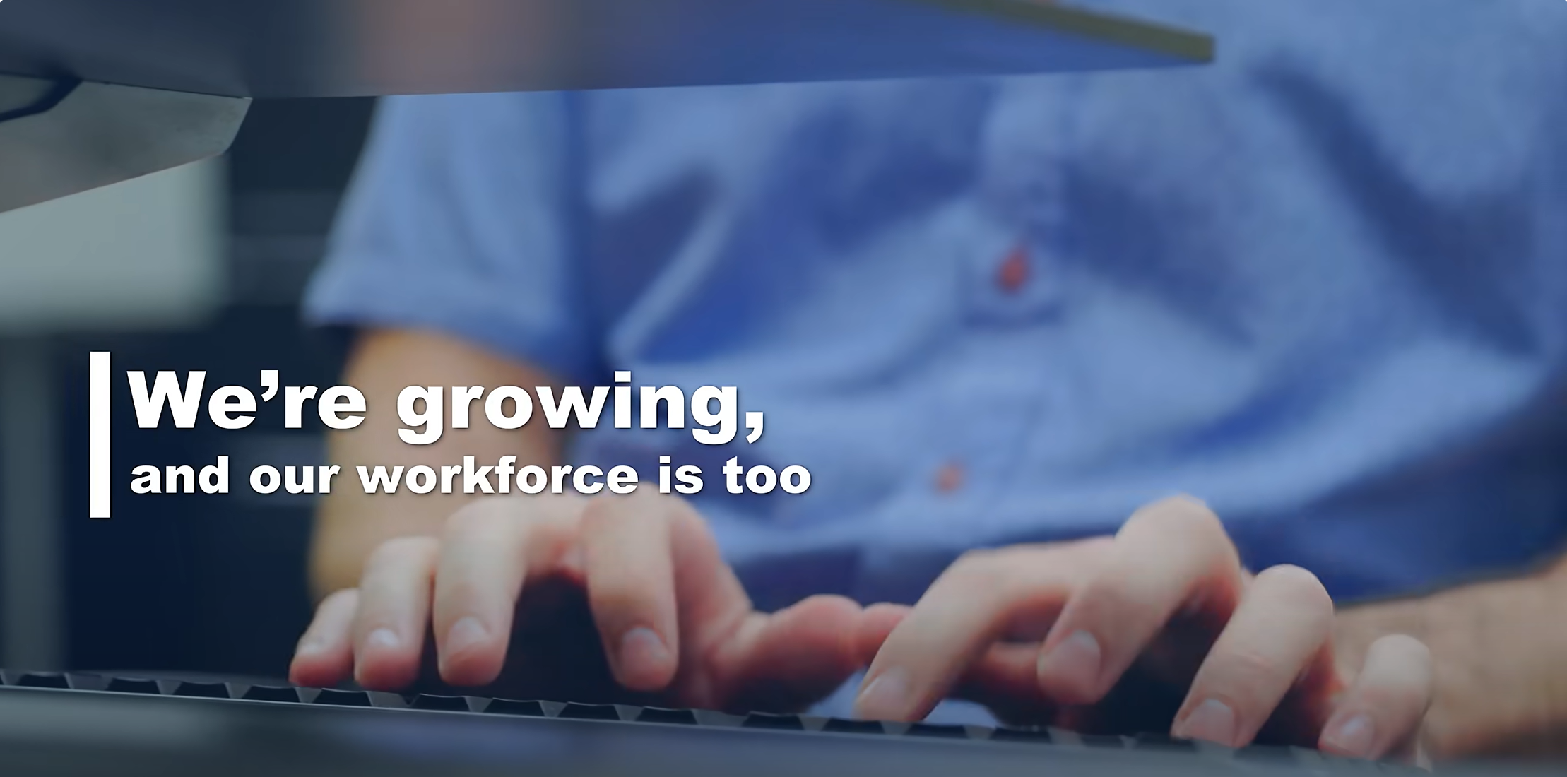 A person wearing a blue shirt typing on a keyboard, with the text overlay: 'We're growing, and our workforce is too.