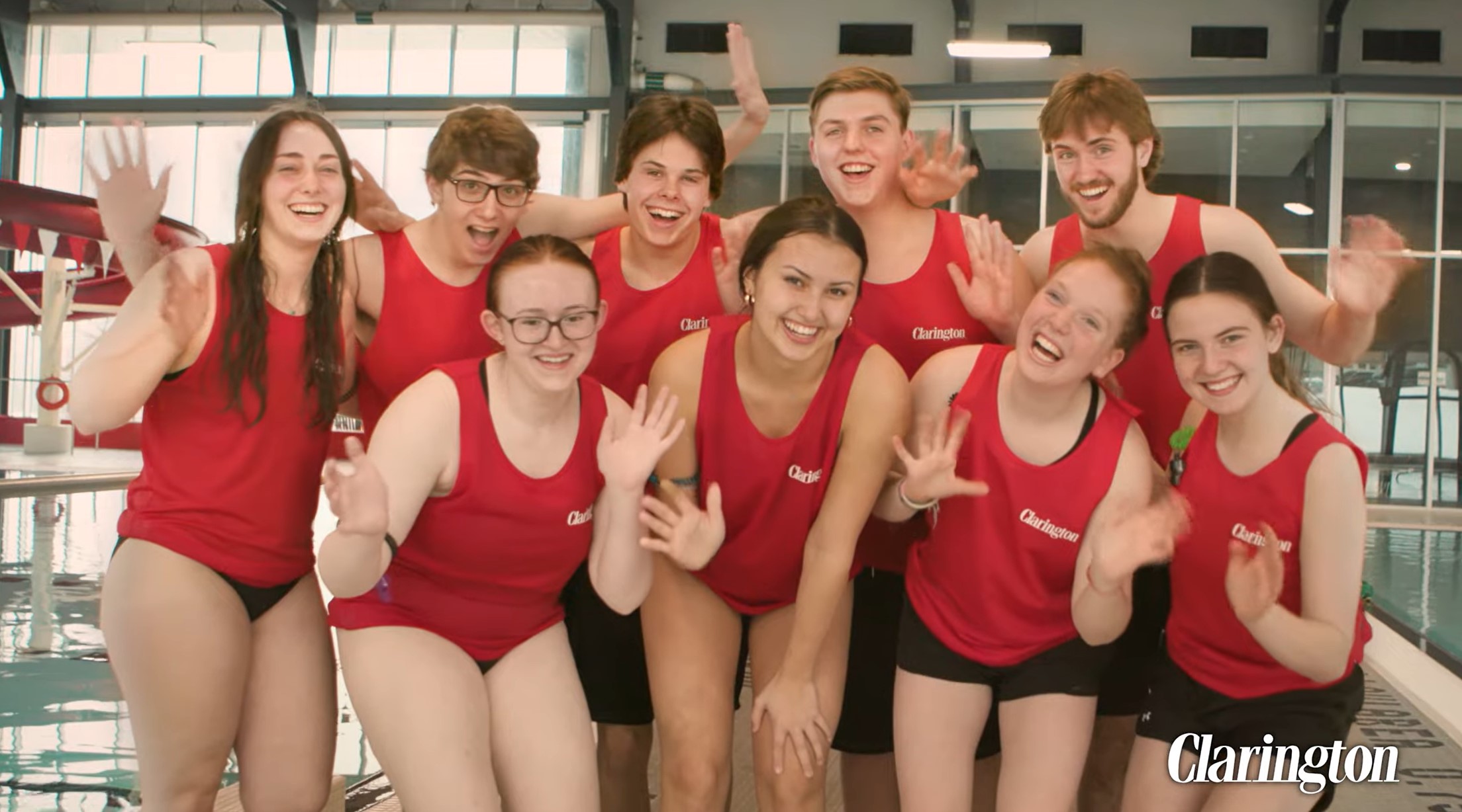 Lifeguards smiling and laughing together on the pool deck.